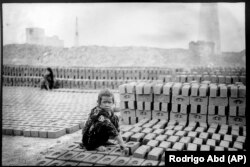 Marwan, 7 vjeç, nxjerr një copë baltë me duar, dhe e ngjesh atë derisa të ketë fortësinë e mjaftueshme për ta vendosur në një kallëp, në një fabrikë tullash në periferi të Kabulit më 30 maj.