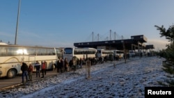 Serbët e Kosovës qëndrojnë në radhë në pikën kufitare Kosovë-Serbi në Merdarë, Kosovë, 17 dhjetor 2023. Ata udhëtuan me autobusë dhe automjete nga pjesë të ndryshme të Kosovës për të votuar për zgjedhjet parlamentare në Serbi të dielën.