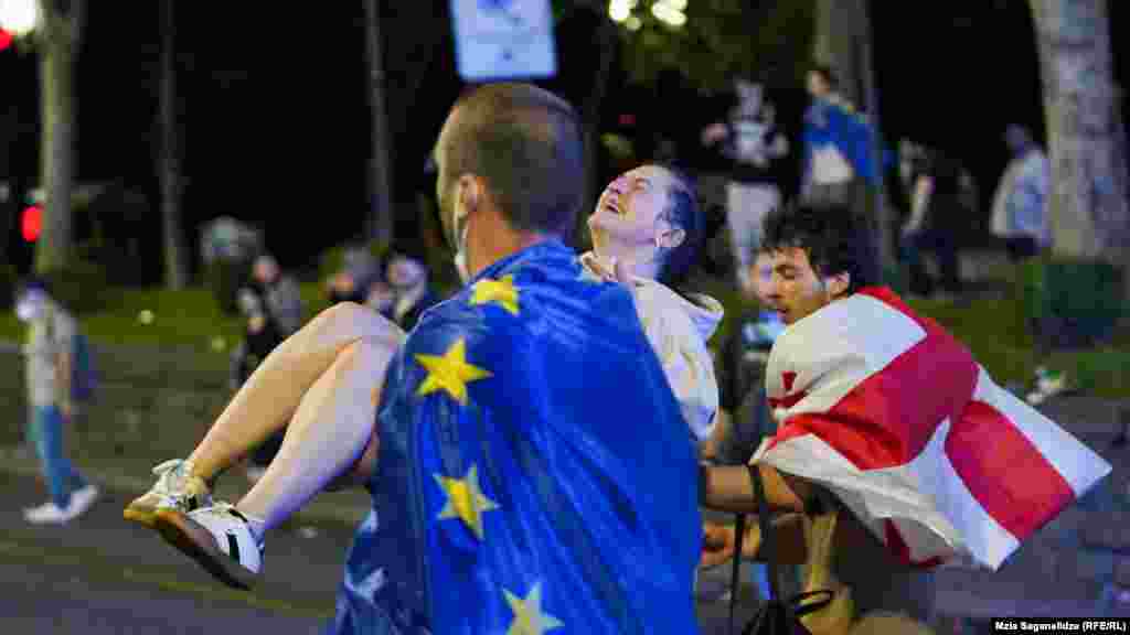 A man draped in an EU flag carries an injured protester. Supporters of the bill say it mirrors similar U.S. legislation and promotes transparency. Opponents say the proposed legislation would stifle dissent and silence independent media. They have compared it to similar legislation in Russia, which is why many call it the "Russian law."&nbsp;