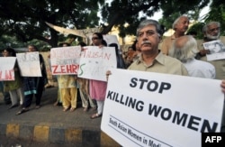 Activiști pakistanezi pentru drepturile omului la un protest în orașul port maritim Karachi din sudul țării pentru a protesta împotriva uciderii femeilor.