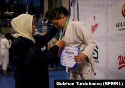 Нуржамал Сагыналиева чемпион болгон кыздарга сыйлык тапшырып жатат.