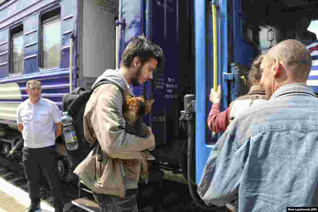 People board an evacuation train at the railway station in Kherson. &nbsp;