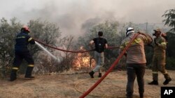 Пожарникари и доброволци гасят пожара, обхванал Неа Анхиалос.