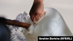 Një person duke mbushur një bidon me ujë. 23 tetor 2023. 