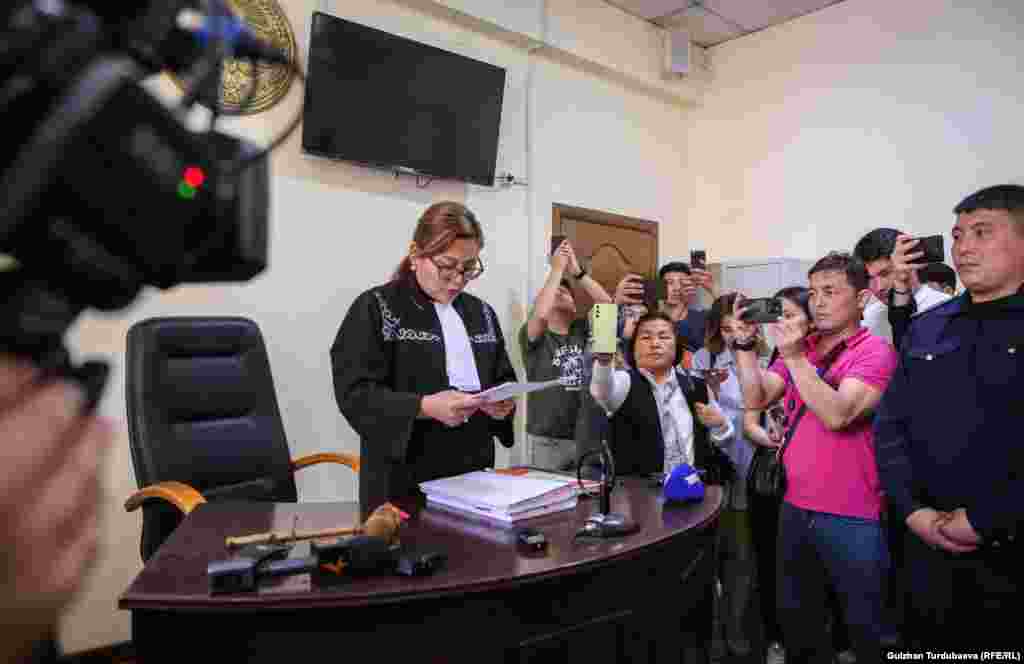 27-апрель. Бишкектин Ленин райондук соту. &ldquo;Азаттыктын&rdquo; ишин караган судья Чолпон Каримбаева "Азаттык Медианын" ишмердигин токтотуу чечимин окуп жаткан учуру.&nbsp; 12-июлда, тагыраагы, эки айдан кийин Бишкек шаардык соту Маданият, маалымат, спорт жана жаштар саясаты министрлиги менен "Азаттык Медиа" мекемесинин ортосундагы тынчтык келишимин бекитип, Ленин райондук сотунун 27-апрелдеги "Азаттыктын" ишмердигин токтотуу боюнча чечимин жокко чыгарып, соттук териштирүүнү токтотту.