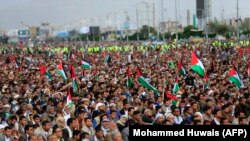 იემენელ მუსლიმებს პარასკევის ლოცვის დროს პალესტინელთა მიმართ სოლიდარობის ნიშნად პალესტინური დროშები უჭირავთ ხელში. ჰუტის მომხრეთა კონტროლის ქვეშ მყოფი ქალაქი სანა. 27 ოქტომბერი, 2023 წელი