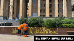 1 მაისის დილას თბილისის დასუფთავების სამსახური შლის პარლამენტის შენობასა და მის მიმდებარე ტერიტორიაზე მოქალაქეების მიერ დატოვებულ წარწერებს. 