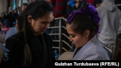 Мариям Курманалиева (кара кийимчен).