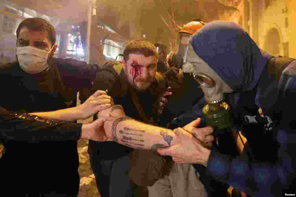 Protesters help an injured man during a rally in Tbilisi.&nbsp; At least 11 people, including six police officers, were receiving hospital treatment after being injured, according to Georgia's Health Ministry. &nbsp;