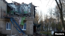 În imagine, un polițist inspectează clădirea unei grădinițe avariate în urma atacului armatei ruse asupra Kievului.