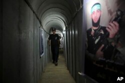 În această fotografie din 2016, un bărbat palestinian pășește într-un tunel folosit pentru exerciții militare în timpul unei expuneri de arme la o tabără de vară pentru tineri condusă de Hamas din orașul Gaza.