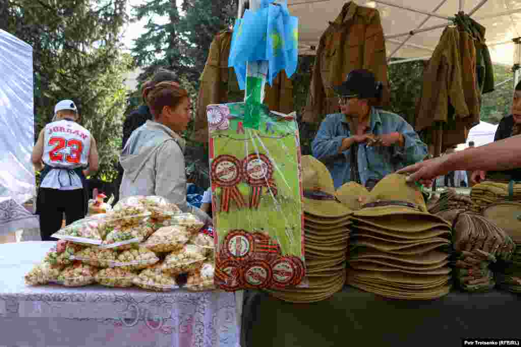 По обочинам выстроились торговые ряды: продавали еду, военную атрибутику и значки, выполненные в цветах георгиевской ленты