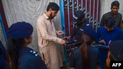 په کراچۍ کې پولیس د لټون عملیاتو پر مهال د یو افغان کډوال د ګوتې نښه ثبتوي - د نومبر ۱۷مې انځور.