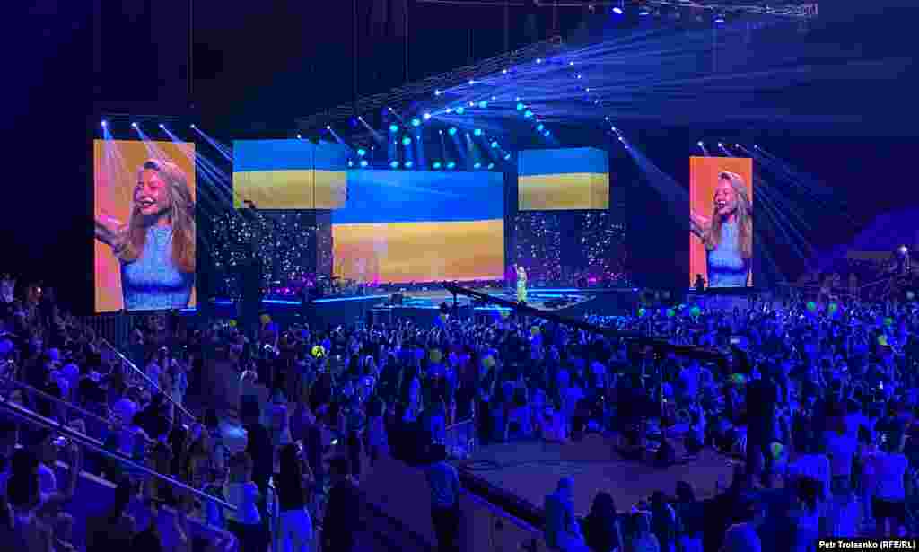 Азаттық Украина атрибуттарына концертке алып кіруге кімнің тыйым салып жатқанын білмекке талпынып көрді. "Алматы арена" сарайының өкілдері барлық сауалды концертті&nbsp; ұйымдастырушылар мен қалалық полиция департаментіне қойыңыздар деді. Ұйымдастырушылар Украина туы мен атрибуттарына концертке кіргізуге Алматы әкімдігі тыйым салды" деді. Ал қалалық мәдениет басқармасының басшысы Ғани Майлыбаев "білмейміз, бұл шараны біз ұйымдастырған жоқпыз" деп жауап берді.