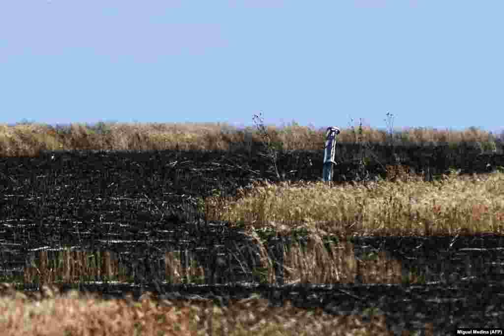 Urmele unei rachete într-un câmp de grâu, într-o zonă nespecificată din Ucraina. Din cauza blocadei navale, porturile Ucrainei de la Marea Neagră sunt inactive, ceea ce blochează rutele de aprovizionare inclusiv către națiuni africane care depind de grâul ucrainean. &nbsp;