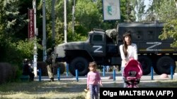 Жители оккупированной Россией части Херсонской области на фоне российской военной техники