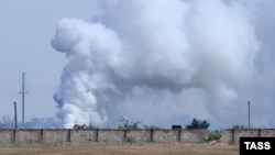 Fumul se ridică deasupra locului unde a avut loc explozia, la un depozit de muniții, în Crimeea ocupată de Rusia, 16 august 2022