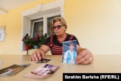 Gjyla Gashi derisa mbanë në duar fotografinë e vajzës së saj të vrarë në luftë, Besartës që ishte 13-vjeçare.