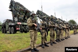 Soldați în așteptarea președintelui Zelenski la o bază din Germania, în iunie 2024. Bateriile Patriot, din spatele lor, fabricate în SUA, sunt dorite de Kiev în număr cât mai mare.