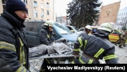 Украина, Харьков.  Куткаруучулар ракеталык аткылоодон жаракат алган кишини көтөрүп баратышат.  1-март, 2022-жыл.