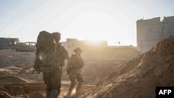 نیرو های اسرائیلی در بخشی از شهر ویران شدهٔ غزه