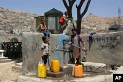 Ер адам балаларымен ортақ құдықтан су алып жатыр. Кабул, Ауғанстан. 30 шілде, 2018 жыл. (AP Photo/Rahmat Gul)