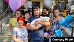 Семей қаласының тұрғыны Руслан Карашевтің (ортада) перзентханадан шыққан әйелі мен баласын туыстарымен бірге қарсы алған кезде түскен суреті. Жеке архивтегі фото.