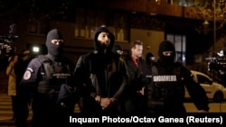 Andrew și Tristan Tate, încătușați și escortați de forțe de ordine la sediul DIICOT din București. Ei au fost reținuți pentru 24 de ore pe 29 decembrie 2022.