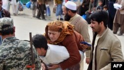 عکس آرشیف: یک مرد افغان مادر بیمار خود را به آنسوی مرز٬ به پاکستان انتقال می دهد. 