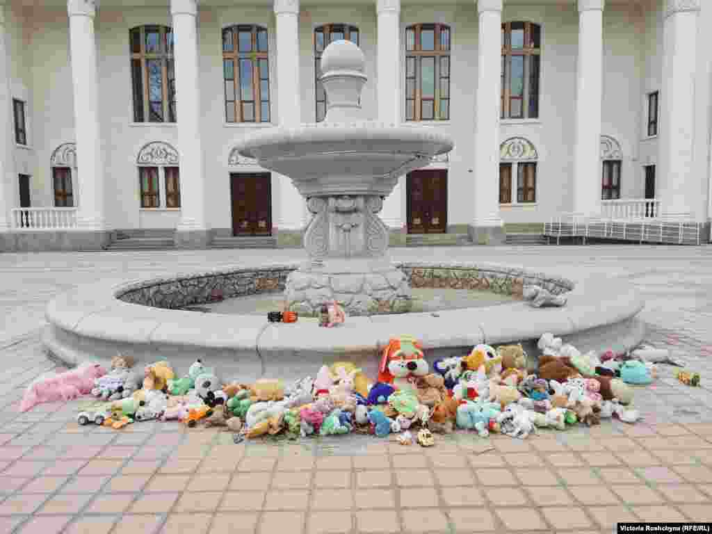 An impromptu memorial for children who have died during the war in front of the Palace of Culture in the town of Nova Kakhovka in the Kherson region. "This building is opposite the Russian commandant's office," said one man as he walked by. "They bring toys here so that they can see and remember."&nbsp;