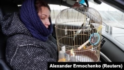 A Ukrainian woman flees occupied Mariupol in 2022.