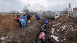 Cadavre îngropate într-o groapă comună din Mariupol/Ucraina. 