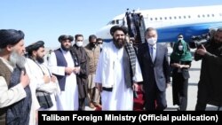 د طالبانو د بهرنیو چارو سرپرست وزیر امیر خان متقي پر کابل هوايي ډګر د چین د بهرنیو چارو وزیر وانګ يي هرکلی کوي - پخوانی انځور.