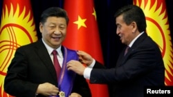 Kyrgyz President Sooronbai Jeenbekov (right) awards Chinese President Xi Jinping with the Manas Order at a meeting in Bishkek in June 2019. 