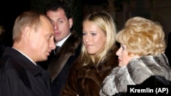 Russian President Vladimir Putin (left) speaks with Ksenia Sobchak (center) during a visit to her father's grave in 2003. Anatoly Sobchak's widow, Lyudmila Narusova, is on the right. (file photo)