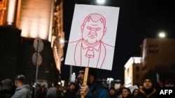 Протестиращ държи плакат по време на антиправителствения протест в София, 1 декември 2025 г.