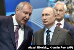 Președintele Vladimir Putin (dreapta) îl ascultă pe șeful de atunci al Roskosmos, Dmitri Rogozin, aprilie 2019.