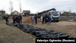 Cadavre ale civililor despre care oficialii ucraineni spun că au fost uciși în timpul invaziei Rusiei și apoi exhumați dintr-o groapă comună din orașul Bucea, în afara Kievului, 8 aprilie 2022.