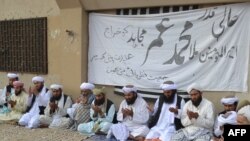 Pakistan members of Jamiat Ulma-e Islam Nazraiti party pray for Afghanistan's Taliban chief Mullah Mohammad Omar at a ceremony in Quetta on July 31