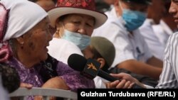 "Азаттык" радиосунун кабарчысы Бишкектеги иш-чаралардын биринде энелерди кепке тартууда. 