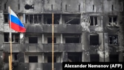 Руско знаме се вее покрај зградите уништени од руското гранатирање во Мариупол на 12 април.