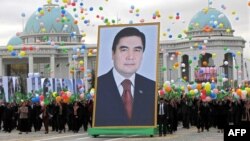 Люди несут портрет президент Туркменистана Гурбангулы Бердымухамедова во время празднования Дня независимости Туркменистана. Ашгабат, 27 октября 2009 года.