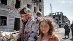 Copii din Mariupol ademeniți de invadatori la sărbătoarea Zilei Victoriei, după mai mult de două luni de bombardamente neîntrerupte. Localnicilor le-au fost oferite conserve cu carne desfăcute, baloane și panglica Sf. Gheorghe, devenită simbol al invaziei rusești în Ucraina.