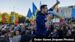 Liderul partidului AUR, George Simion, în timp ce vorbește la portavoce în Piața Victoriei. El s-a certat cu senatoarea Diana Șoșoacă, fostă membră de partid, și s-au acuzat reciproc de confiscarea manifestației.