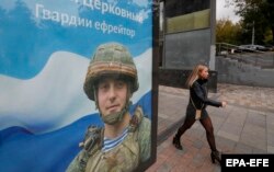 A woman in Moscow walks past a recruitment poster for the Russian armed forces on September 26.