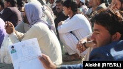 په خوست کې یوشمېر کسان د پاسپورټونو د فورمونو جمع کولو لپاره په قطارونو کې ناست دي - پخوانی انځور. 