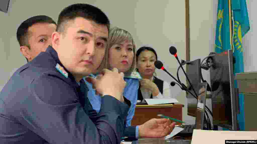 Прокурор Әсел Таңалиева Ақтөбедегі Қаңтар оқиғасында 33 полиция қызметкері түрлі жарақат алғанын айтты. Сотқа жәбірленуші ретінде шақырылған полиция қызметкерлері Қаңтар оқиғасынан соң айып тағылып, сотқа тартылған 18 адамның бәрін тани алмады. Жәбірленушілер сотта "алаңда адам көп болды, ескілеу КАМАЗ көлігі тас әкеліп төкті, көлік жүргізушісін көрмедім" деген сыңайлы жалпылама жауап берді. Суретте: Қаңтар оқиғасына байланысты айып тағылған 18 азаматтың ісі бойынша сот процесіне қатысып отырған мемлекеттік айыптаушылар Саламат Амандықов (алдыңғы жақта) пен Әсел Таңалиева.