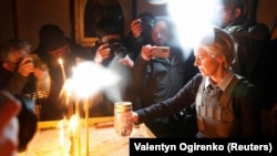 Șefa Comisiei Europene aprinde o lumânare la o biserică din Bucea, Ucraina, 8 aprilie 2022.