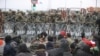 Migrants gather on the Belarusian-Polish border, while Polish military police stand guard on the Polish side of the frontier, at the Bruzgi-Kuznica border crossing on November 15.