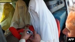 یو روغتیايي کارکوونکی د وزيرستان يو ماشوم ته واکسیني څاڅکي ورکوي - انځور له ارشيفه 